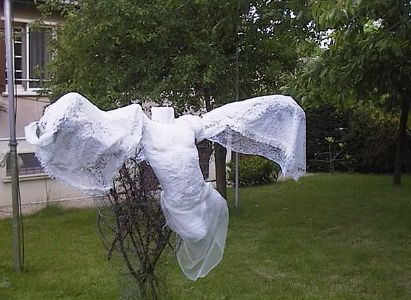 Angel — wire sculpture with white lace wings, outdoors